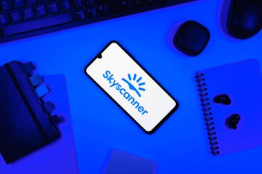 Prag, Çek Cumhuriyeti - 05: 18 2025: Skyscanner logosunu gösteren bir telefonla ofis masasına yerleştirilmiş nesneler.