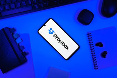 Prag, Çek Cumhuriyeti - 05: 18 2025: Dropbox logosunu gösteren bir telefonla ofis masasına yerleştirilmiş nesneler.