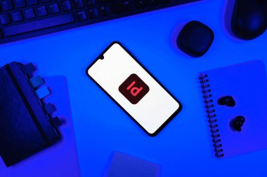 Prag, Çek Cumhuriyeti - 05: 18 2025: Tasarım logosunu gösteren bir telefonla bir ofis masasına yerleştirilmiş nesneler.