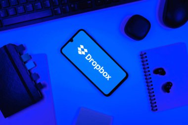 Prag, Çek Cumhuriyeti - 05: 18 2025: Dropbox logosunu gösteren bir telefonla ofis masasına yerleştirilmiş nesneler.