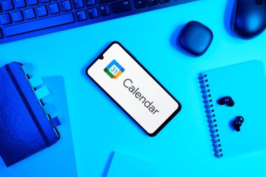 Prag, Çek Cumhuriyeti - 05: 18 2025: Google Takvim logosunu gösteren bir telefonla ofis masasına yerleştirilmiş nesneler.