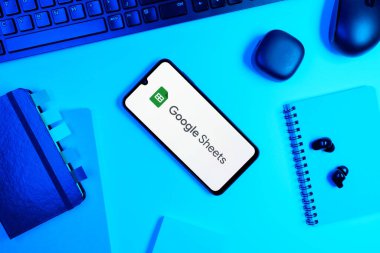 Prag, Çek Cumhuriyeti - 05: 18 2025: Google Sheets logosunu gösteren bir telefonla ofis masasına yerleştirilmiş nesneler.