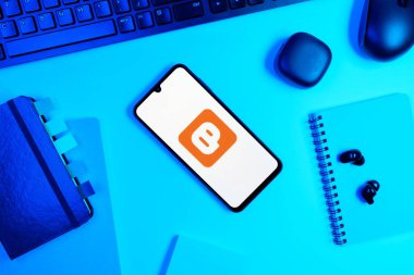 Prag, Çek Cumhuriyeti - 05: 18 2025: Blogcu logosunu gösteren bir telefonla ofis masasına yerleştirilmiş nesneler.