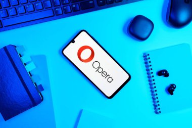 Prag, Çek Cumhuriyeti - 05: 18 2025: Opera logosunu gösteren bir telefonla ofis masasına yerleştirilmiş nesneler.