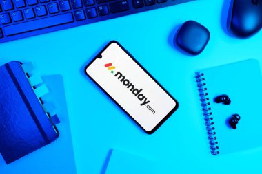 Prag, Çek Cumhuriyeti - 05: 18 2025: Monday.com logosunu gösteren bir telefonla ofis masasına yerleştirilmiş nesneler.