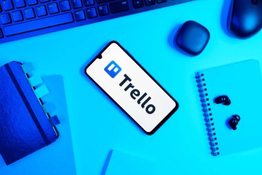 Prag, Çek Cumhuriyeti - 05: 18 2025: Trello logosunu gösteren bir telefonla ofis masasına yerleştirilmiş nesneler.