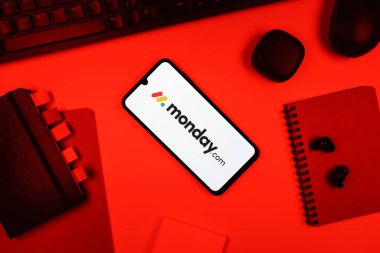 Prag, Çek Cumhuriyeti - 05: 18 2025: Monday.com logosunu gösteren bir telefonla ofis masasına yerleştirilmiş nesneler.