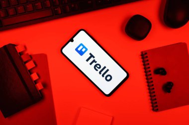 Prag, Çek Cumhuriyeti - 05: 18 2025: Trello logosunu gösteren bir telefonla ofis masasına yerleştirilmiş nesneler.