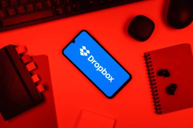 Prag, Çek Cumhuriyeti - 05: 18 2025: Dropbox logosunu gösteren bir telefonla ofis masasına yerleştirilmiş nesneler.