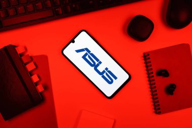 Prag, Çek Cumhuriyeti - 05: 18 2025: Asus logosunu gösteren bir telefonla ofis masasına yerleştirilmiş nesneler.