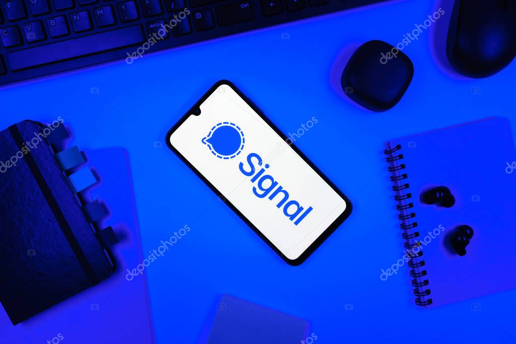 Prague, Czechia - 05 18 2025: Objects arranged on an office desk with a phone showing Signal logo.