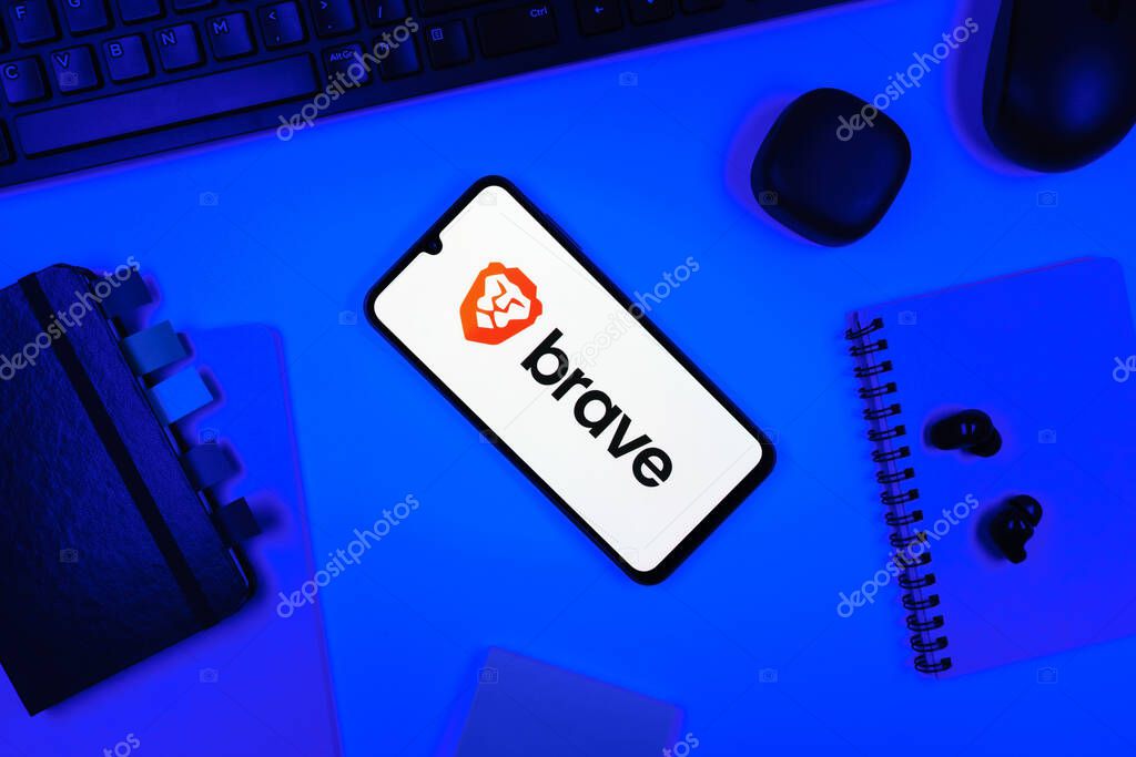Prague, Czechia - 05 18 2025: Objects arranged on an office desk with a phone showing Brave logo.