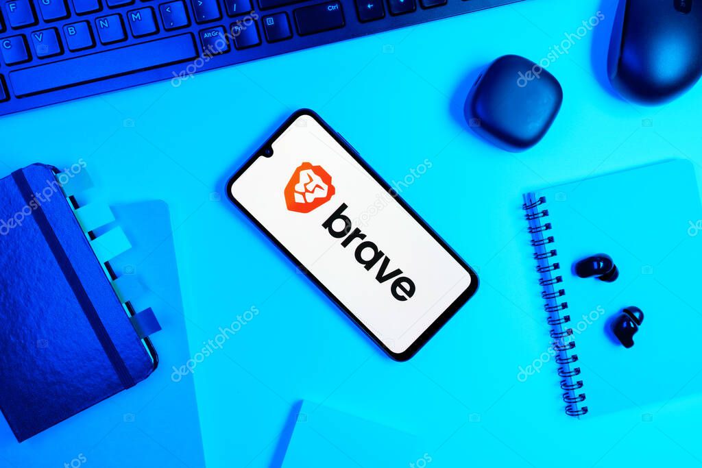 Prague, Czechia - 05 18 2025: Objects arranged on an office desk with a phone showing Brave logo.