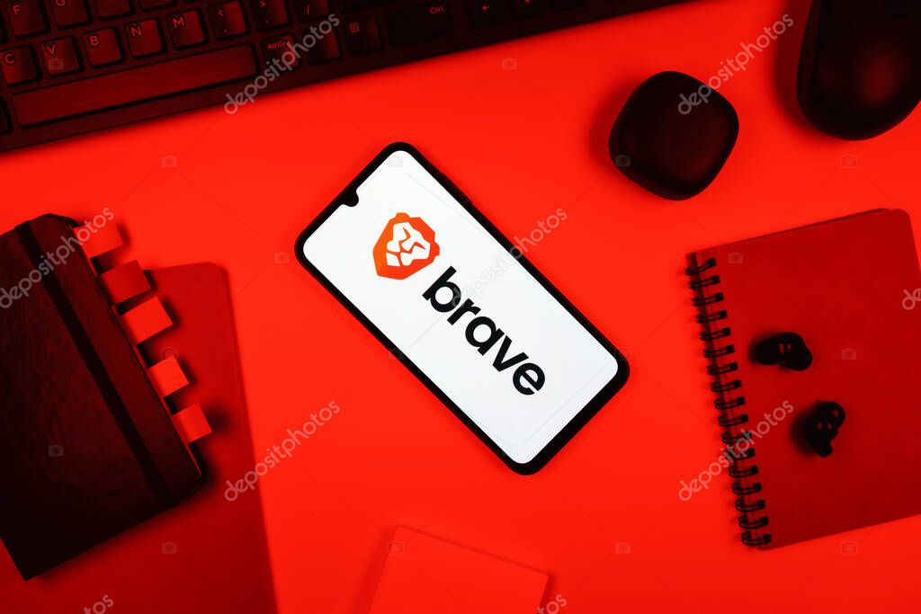 Prague, Czechia - 05 18 2025: Objects arranged on an office desk with a phone showing Brave logo.