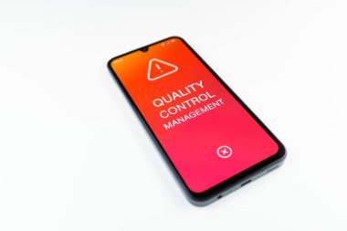 Açık mavi arkaplandaki telefon Kalite Kontrol Yönetimi metnini görüntüler.