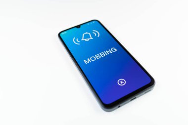Açık mavi arkaplandaki telefon Mobbing metnini görüntüler.