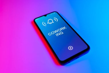 Mor ve mavi arkaplandaki telefon eşzamanlı metin görüntüler.