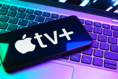 Prag, Çek Cumhuriyeti - 08 01 2025: Laptop klavyesinde uzanan bir cep telefonu Apple TV + logosunu gösteriyor. Apple TV +, filmler ve TV programları için bir yayın platformudur..