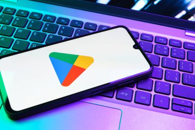Prag, Çek Cumhuriyeti - 08 01 2025: Dizüstü bilgisayarda bulunan bir cep telefonu Google Play logosunu görüntüler. Google Play uygulamaları, oyunları ve dijital içeriği indirmek için bir platformdur.