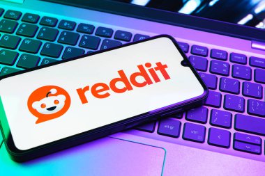 Prag, Çek Cumhuriyeti - 08 01 2025: Dizüstü bilgisayarın üzerinde duran bir cep telefonu Reddit logosunu gösterir. Reddit tartışma, haber ve toplum içeriği için bir platformdur.