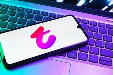 Prag, Çek Cumhuriyeti - 08 01 2025: Dizüstü bilgisayarın üzerinde duran bir cep telefonu Tango logosunu gösteriyor. Tango, görüntülü aramalar, mesajlar ve canlı yayınlar için sosyal bir uygulama..