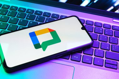 Prag, Çek Cumhuriyeti - 08 01 2025: Dizüstü bilgisayarın üzerinde duran bir cep telefonu Google Chat logosunu görüntüler. Google Chat mesajlaşma ve takım işbirliği için bir platformdur.