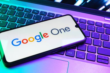 Prag, Çek Cumhuriyeti - 08 01 2025: Dizüstü bilgisayarda bulunan bir cep telefonu Google One logosunu görüntüler. Google 1 bulut depolama ve abonelik hizmetleri için bir platformdur.
