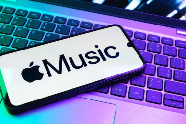 Prag, Çek Cumhuriyeti - 08 01 2025: Laptop klavyesinde uzanan bir cep telefonu Apple Music logosunu gösteriyor. Apple Music müzik için bir platformdur..