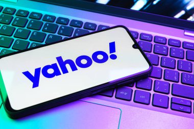 Prag, Çek Cumhuriyeti - 08 01 2025: Laptop klavyesinde duran bir cep telefonu Yahoo logosunu gösteriyor. Yahoo haber, e-posta ve internet hizmetleri için bir platformdur..
