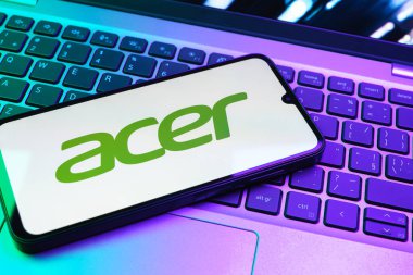 Prag, Çek Cumhuriyeti - 08 01 2025: Dizüstü bilgisayarın üzerinde duran bir cep telefonu Acer logosunu gösterir. Acer bilgisayar ve elektronik üreten bir teknoloji şirketidir..