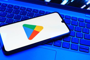 Prag, Çek Cumhuriyeti - 08 01 2025: Dizüstü bilgisayarda bulunan bir cep telefonu Google Play logosunu görüntüler. Google Play uygulamaları, oyunları ve dijital içeriği indirmek için bir platformdur.