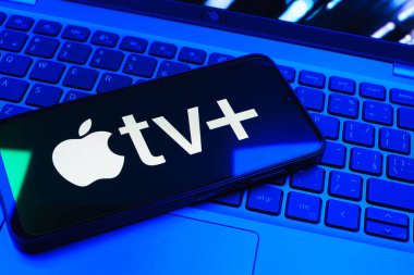 Prag, Çek Cumhuriyeti - 08 01 2025: Laptop klavyesinde uzanan bir cep telefonu Apple TV + logosunu gösteriyor. Apple TV +, filmler ve TV programları için bir yayın platformudur..