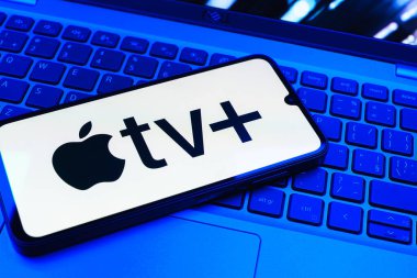 Prag, Çek Cumhuriyeti - 08 01 2025: Laptop klavyesinde uzanan bir cep telefonu Apple TV + logosunu gösteriyor. Apple TV +, filmler ve TV programları için bir yayın platformudur..