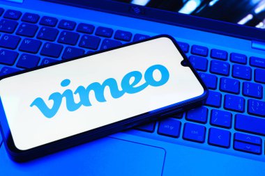 Prag, Çek Cumhuriyeti - 08 01 2025: Dizüstü bilgisayarın üzerinde duran bir cep telefonu Vimeo logosunu gösterir. Vimeo, yüksek kaliteli video sunucu ve paylaşımı için bir platformdur.