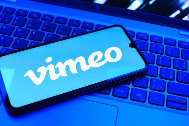 Prag, Çek Cumhuriyeti - 08 01 2025: Dizüstü bilgisayarın üzerinde duran bir cep telefonu Vimeo logosunu gösterir. Vimeo, yüksek kaliteli video sunucu ve paylaşımı için bir platformdur.