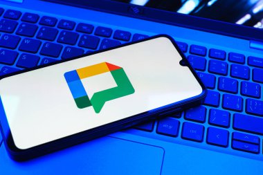 Prag, Çek Cumhuriyeti - 08 01 2025: Dizüstü bilgisayarın üzerinde duran bir cep telefonu Google Chat logosunu görüntüler. Google Chat mesajlaşma ve takım işbirliği için bir platformdur.
