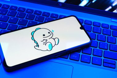 Prag, Çek Cumhuriyeti - 08 01 2025: Dizüstü bilgisayarın üzerinde duran bir cep telefonu Bigo Live logosunu gösteriyor. Bigo Live canlı yayın ve sosyal etkileşim için bir platformdur.