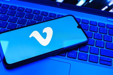 Prag, Çek Cumhuriyeti - 08 01 2025: Dizüstü bilgisayarın üzerinde duran bir cep telefonu Vimeo logosunu gösterir. Vimeo, yüksek kaliteli video sunucu ve paylaşımı için bir platformdur.