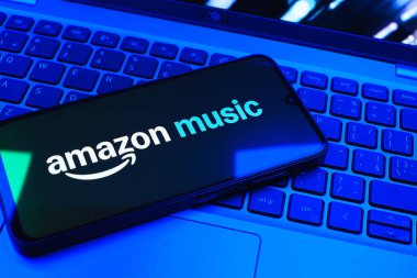 Prag, Çek Cumhuriyeti - 08 01 2025: Laptop klavyesinde uzanan bir cep telefonu Amazon Müzik logosunu gösteriyor. Amazon Müzik müzik müzik için bir platformdur..