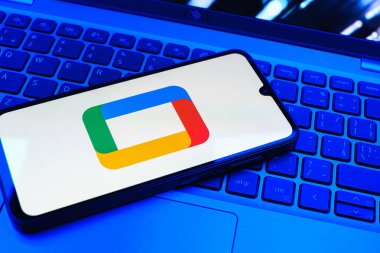 Prag, Çek Cumhuriyeti - 08 01 2025: Laptop klavyesinde uzanan bir cep telefonu Google TV logosunu gösteriyor. Google TV film, program ve uygulamalar için bir platformdur..