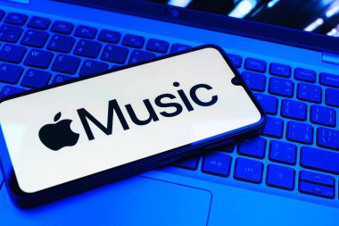 Prag, Çek Cumhuriyeti - 08 01 2025: Laptop klavyesinde uzanan bir cep telefonu Apple Music logosunu gösteriyor. Apple Music müzik için bir platformdur..