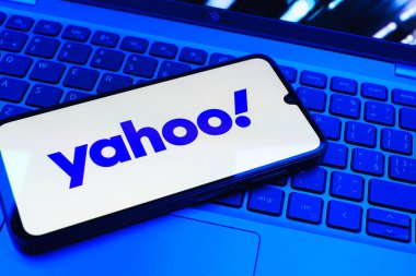 Prag, Çek Cumhuriyeti - 08 01 2025: Laptop klavyesinde duran bir cep telefonu Yahoo logosunu gösteriyor. Yahoo haber, e-posta ve internet hizmetleri için bir platformdur..