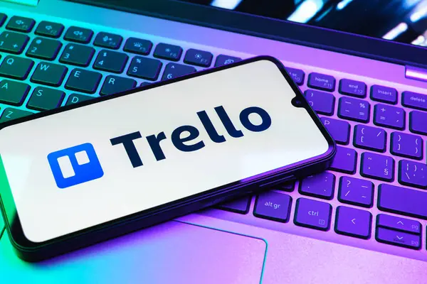 Prag, Çek Cumhuriyeti - 08 01 2025: Dizüstü bilgisayarın üzerinde duran bir cep telefonu Trello logosunu gösterir. Trello, tahta ve görevleri kullanarak proje yönetimi için bir platformdur.