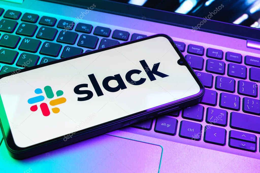 Prague, Czechia - 08 01 2025: A mobile phone lying on a laptop keyboard displays the Slack logo. Slack is a platform for team messaging and workplace communication.