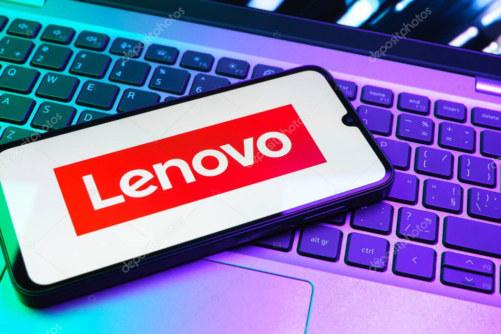 Prague, Czechia - 08 01 2025: A mobile phone lying on a laptop keyboard displays the Lenovo logo. Lenovo is a technology company producing computers and electronics.