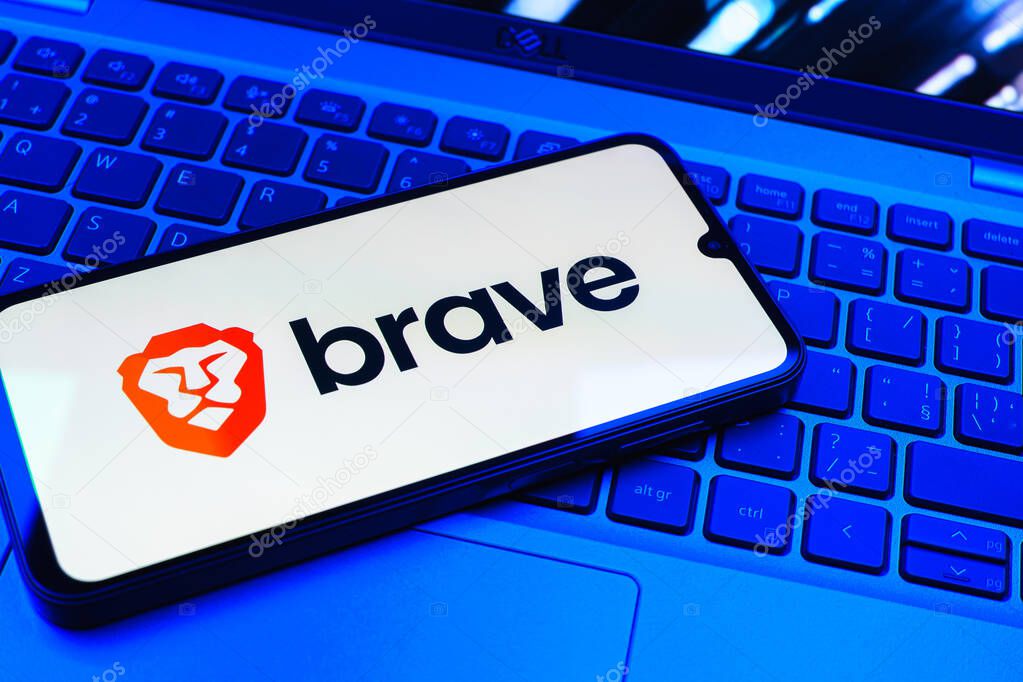 Prague, Czechia - 08 01 2025: A mobile phone lying on a laptop keyboard displays the Brave logo. Brave is a web browser focused on privacy and speed.