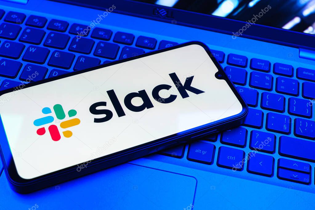 Prague, Czechia - 08 01 2025: A mobile phone lying on a laptop keyboard displays the Slack logo. Slack is a platform for team messaging and workplace communication.