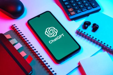 Prag, Çek Cumhuriyeti - 08 18 2025: Merkezinde ChatGPT logosu bulunan bir cep telefonu ile ofis malzemeleri düzenlemesi. ChatGPT metin üretmek ve soruları cevaplamak için bir yapay zeka sohbet robotudur..