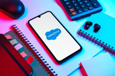 Prag, Çek Cumhuriyeti - 08 18 2025: Merkezde Satış Gücü logosunu gösteren bir cep telefonu ile ofis malzemeleri düzenlemesi. Satış gücü müşteri ilişkileri yönetimi ve bulut hizmetleri için bir platformdur..
