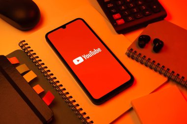 Prag, Çek Cumhuriyeti - 08 18 2025: Merkezde Youtube logosu sergilenen bir cep telefonu ile ofis malzemeleri düzenlemesi. Youtube dünya çapında videoları izlemek ve paylaşmak için bir platform.